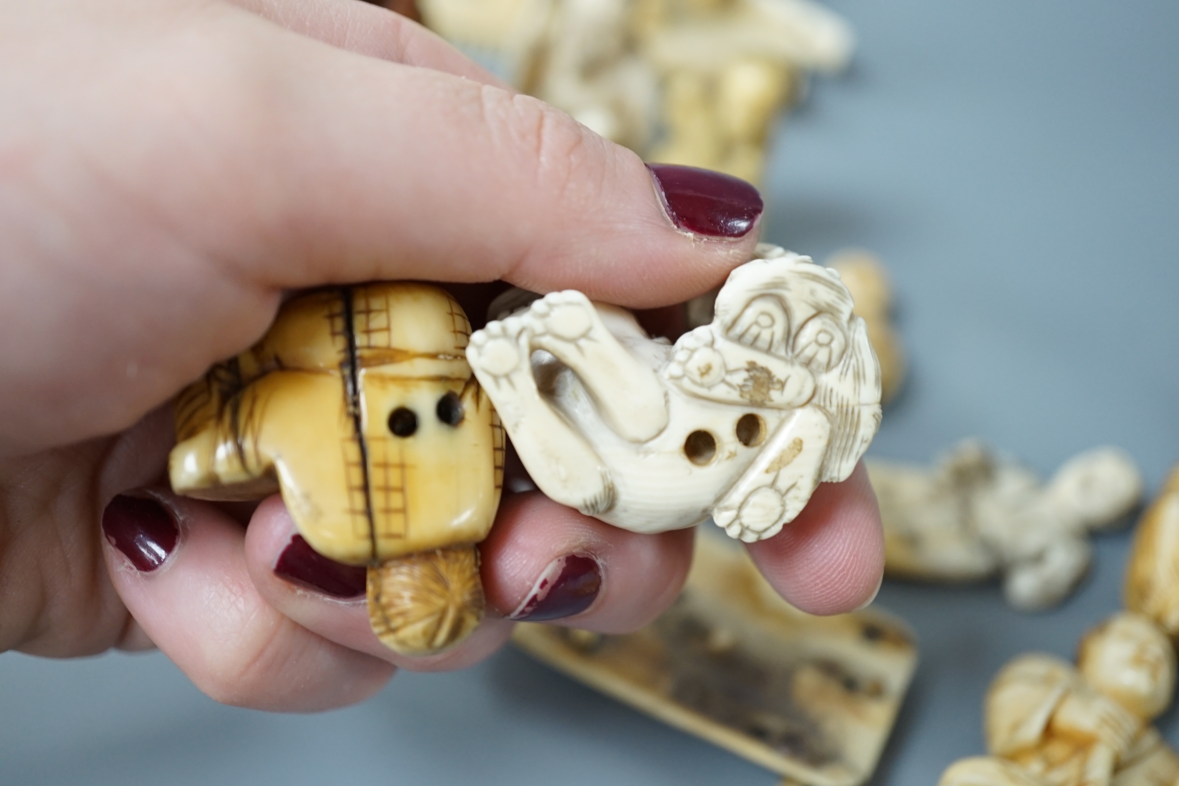A collection of various ivory carvings including netsuke, a soapstone seal and carved wood netsuke